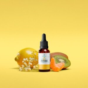 Serum bottle with a dropper surrounded by lemon, kiwi, and orange slices on a bright yellow background.